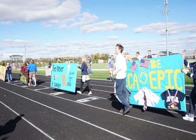 Matt Robbins throws out candy during the Homecoming pep rally while helping to promote and present the DECA banner. DECA is a club for people interested in the business world and leadership. 